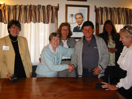 Mayor of Villa La Angostura shaking hands with Arlette Neyens supporting her projects, surrounded by BPW Members.