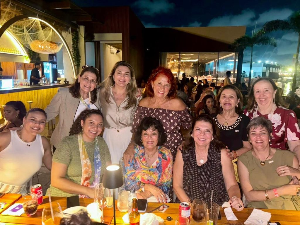 Evening group photo at an open-air restaurant, participants gathered around a table after the day’s meetings.